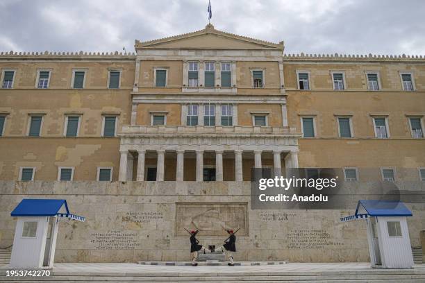 Evzone soldiers perform their ceremonial duties at the Monument of Unknown soldier outside the Greek parliament building in Syntagma square, in...
