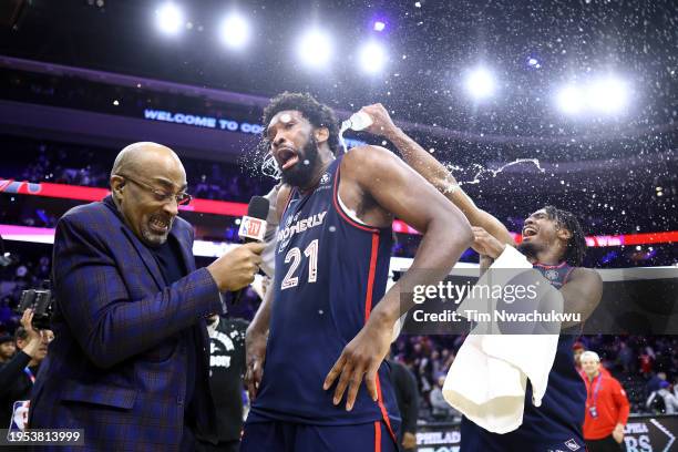 Joel Embiid of the Philadelphia 76ers reacts after being showered with water after defeating the San Antonio Spurs at the Wells Fargo Center on...