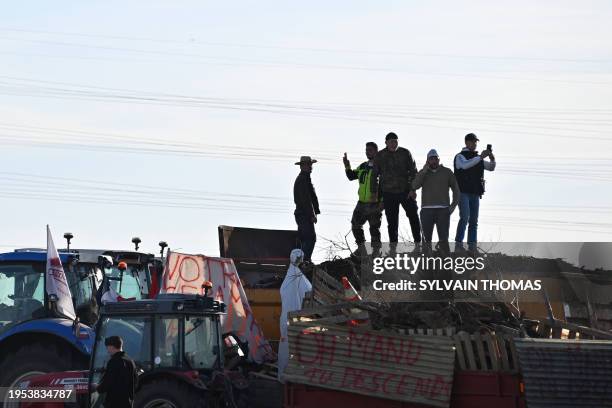 French farmers stand atop a tailer as they block the A9 and A709 highways during a demonstration called by French farmer unions to protest against a...