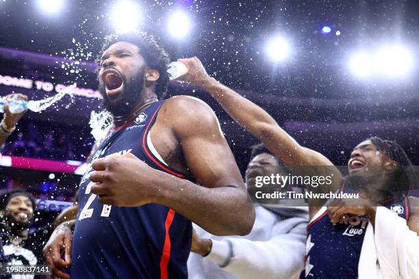 Joel Embiid of the Philadelphia 76ers reacts after being showered with water after defeating the San Antonio Spurs at the Wells Fargo Center on...