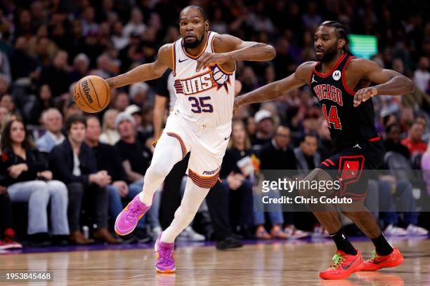 Kevin Durant of the Phoenix Suns drives past Patrick Williams of the Chicago Bulls during the first half at Footprint Center on January 22, 2024 in...