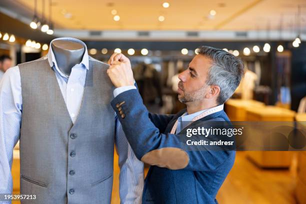 tailor stitching clothes on a mannequin at his shop - tailor stock pictures, royalty-free photos & images