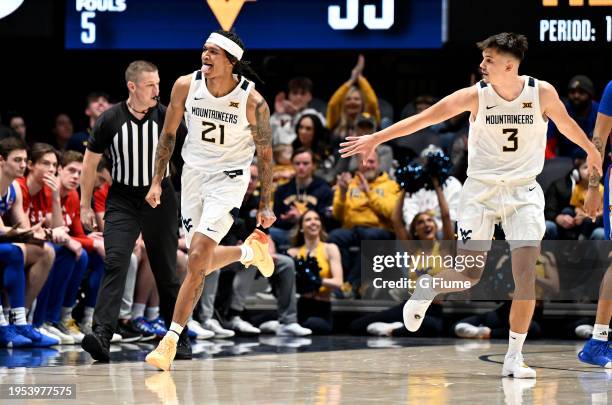 RaeQuan Battle of the West Virginia Mountaineers celebrates with Kerr Kriisa during the game against the Kansas Jayhawks at WVU Coliseum on January...