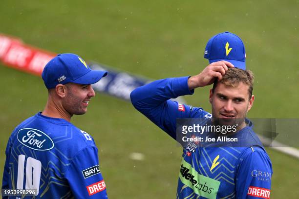 Travis Muller and Dean Foxcroft look on as rain delays play during the T20 Super Smash match between Otago Volts and Northern Districts Brave at...