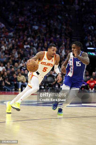 Dejounte Murray of the Atlanta Hawks is guarded by Davion Mitchell of the Sacramento Kings in the second half at Golden 1 Center on January 22, 2024...