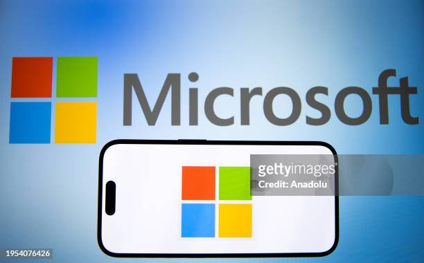 In this photo illustration, 'Microsoft' logo is displayed on mobile phone screen in front of a computer screen in Ankara, Turkiye on January 25, 2024.