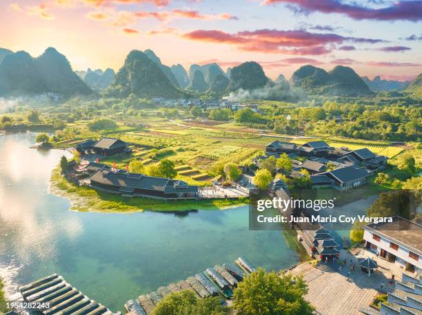 aerial view of shangri-la gardens at sunset, boats in the river, rice fields and karst mountains in the background, yangshuo, guilin, guangxi province, china - yangshuo county guilin guangxi stock pictures, royalty-free photos & images