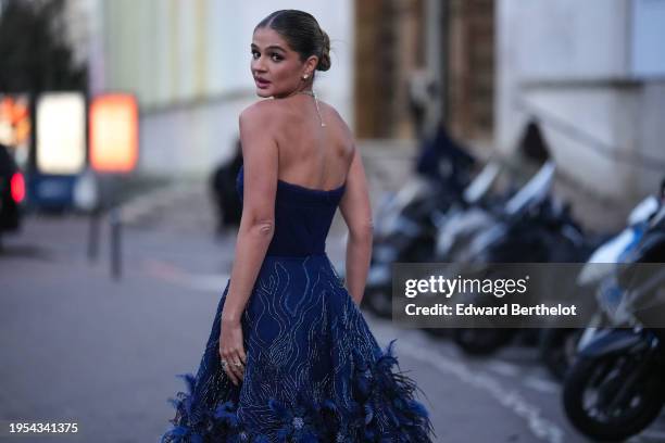 Thassia Naves wears a necklace, a blue bustier off-shoulder low-neck maxi dress with floral print embroidery and feathers details, outside Tony Ward,...