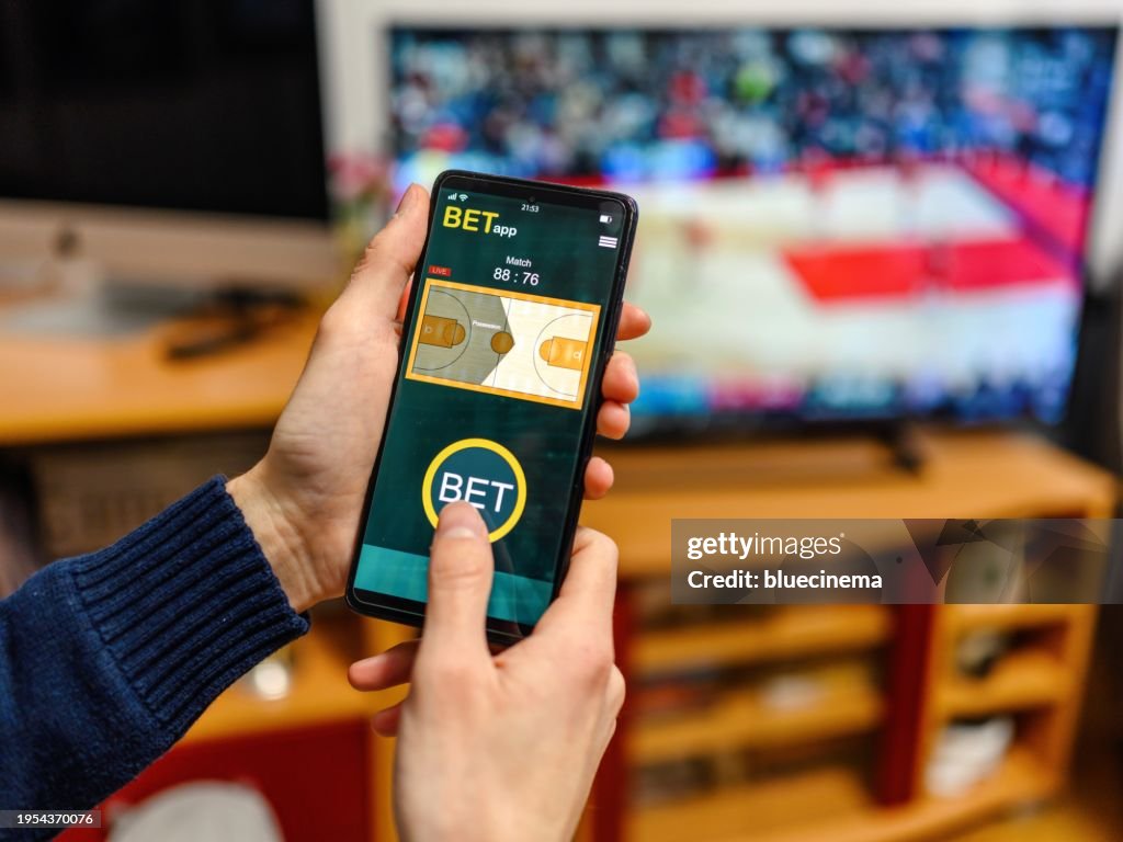 Young men using smart phone for sports betting.