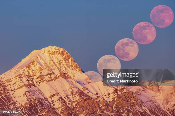 Image is a composition of 5 interval timer photos to show moon rising path) Wolf moon rising next to Corno Grande and Pizzo Cefalone peaks is seen...