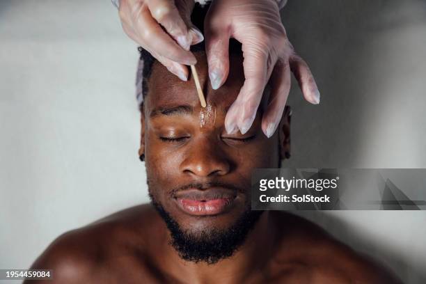 augenbrauen-waxing für männer - male hair removal stock-fotos und bilder