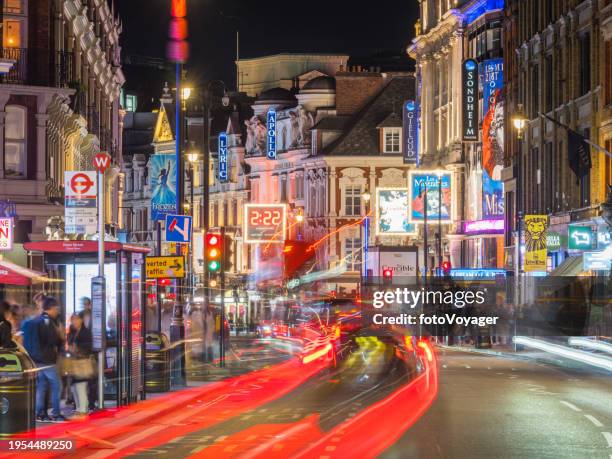 london west end theatreland traffic zooming along shaftsbury avenue night - london theatre stock pictures, royalty-free photos & images