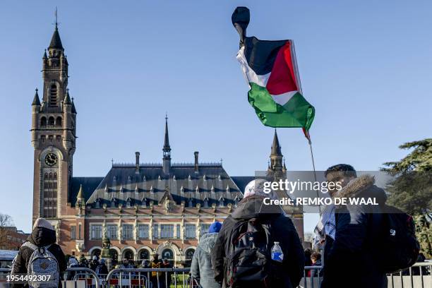 Demonstrator waves the Palestinian flag in front of the Peace Palace ahead of the International Court of Justice verdict in the genocide case against...