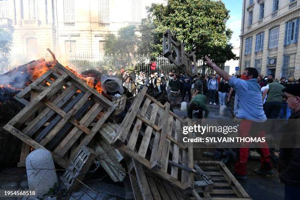 Farmers burn bales of straw and wood in front of the Herault prefecture in Montpellier on January 26 during a demonstration called by French farmer...