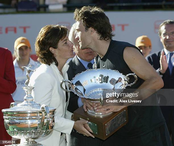 Arantxa Sanchez Vicario of Spain presents Carlos Moya of Spain with the tournament trophy after his victory over Marat Safin of Russia. Safin was...