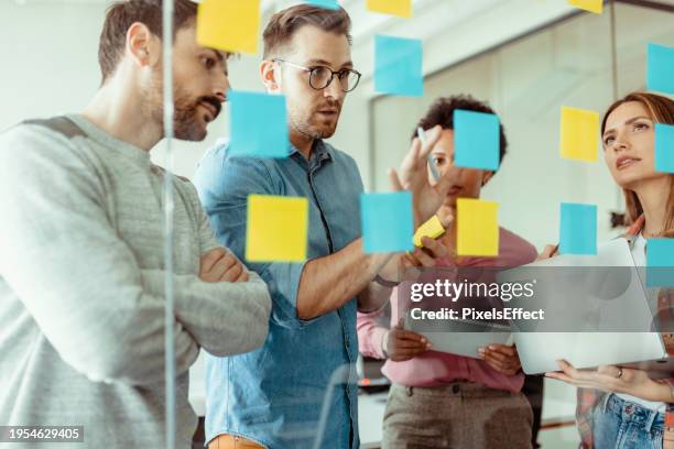 sesión de lluvia de ideas con notas adhesivas durante una reunión - estrategia fotografías e imágenes de stock
