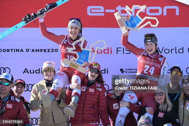 Winner, Austria's Stephanie Venier and third, Austria's Christina Ager, celebrate with their team on the podium of the Women's Downhill event of FIS...