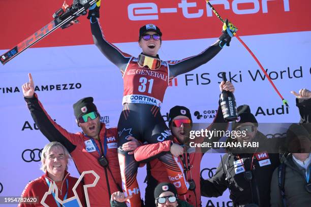 Third, Canada's Valerie Grenier, celebrates with her team on the podium of the Women's Downhill event of FIS Alpine Skiing World Cup in Cortina...