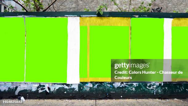 six green backgrounds with irregular contours and different formats on a wall in manhattan, new york city, united states. tree branches and leaves. dirty sidewalk. sunlight. natural colors. no logo or trademark. no graffiti or street art. - wall street poster stock pictures, royalty-free photos & images