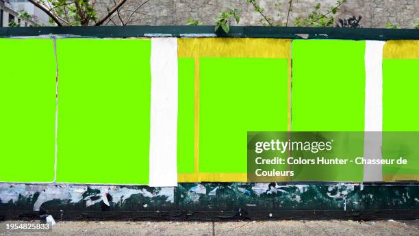 six green backgrounds with irregular contours and different formats on a wall in manhattan, new york city, united states. tree branches and leaves. dirty sidewalk. sunlight. natural colors. no logo or trademark. no graffiti or street art. - patina stock pictures, royalty-free photos & images