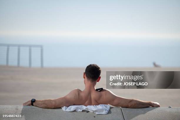 Man sunbathes on San Sebastian beach in Barcelona on January 26, 2024 as temperatures around 30°C were recorded in Spain. Spain is affected by a heat...