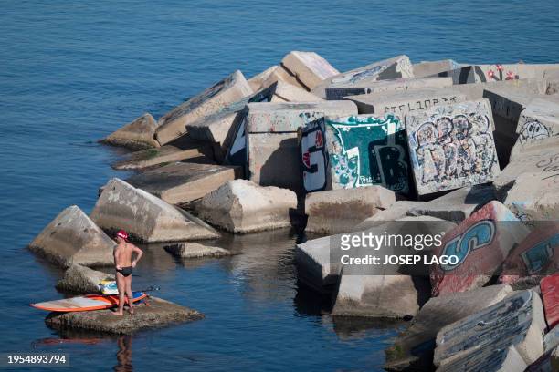 Man sunbathes off San Sebastian beach in Barcelona on January 26, 2024 as temperatures around 30°C were recorded in Spain. Spain is affected by a...