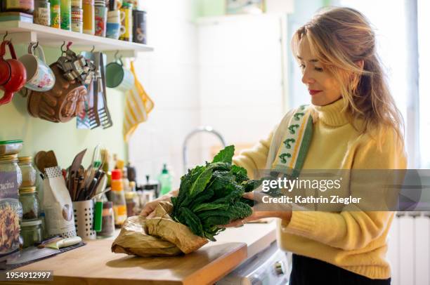 woman in her kitchen, cooking with black cabbage - couve imagens e fotografias de stock