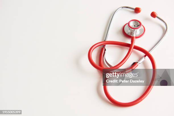 red stethoscope with copy space - red stethoscope stock pictures, royalty-free photos & images