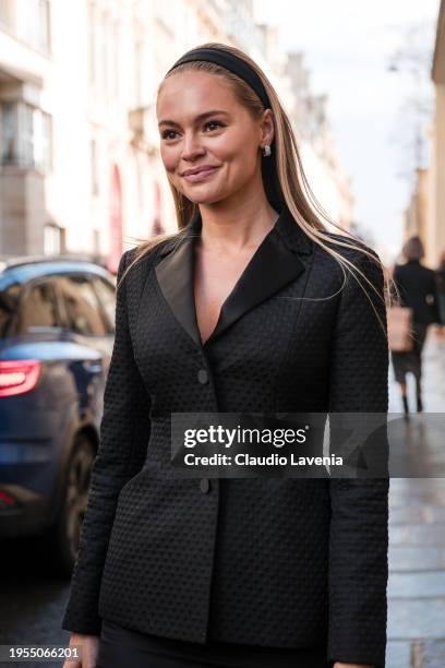 Claire Rose Cliteur wears black blazer with matching midi skirt, light blue Dior bag, outside Christian Dior, during the Haute Couture Spring/Summer...