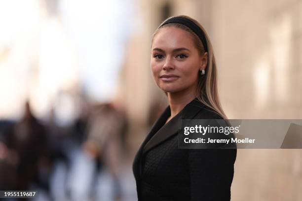 Claire Rose Cliteur seen wearing a black blazer with a matching midi skirt, light blue mini Lady Dior bag, black headband and silver earrings outside...