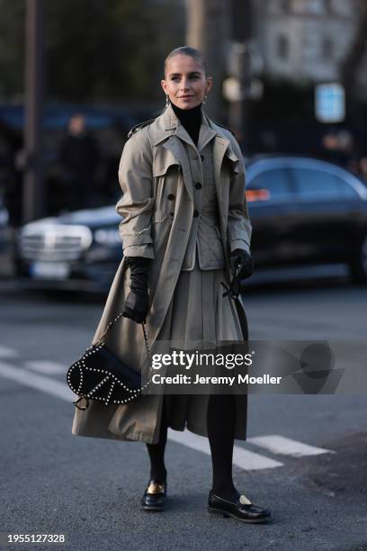 Caroline Daur seen wearing a beige Dior quilted blazer, beige. Pleated beige mini skirt, beige trench coat, black legging tights, black loafer, black...