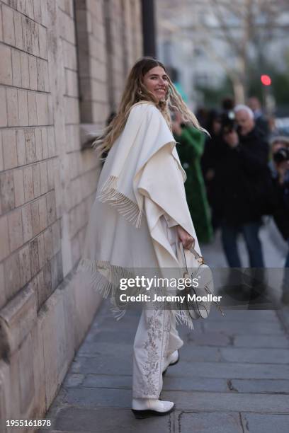 Veronika Heilbrunner seen wearing a cream shirt, cream decorated pants, cream big scarf, white cowboy boots, Dior creem saddle bag, outside Christian...