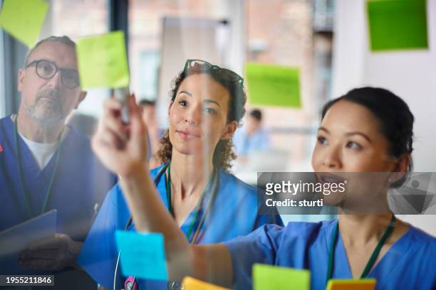 medical team brainstorming - nhs staff fotografías e imágenes de stock