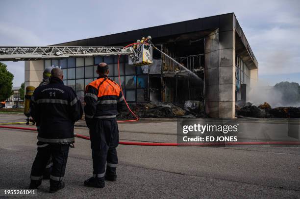 Firefighters tackle a blaze at the MSA Grand Sud building following a farmers' protest against taxation and declining income, in Narbonne on January...