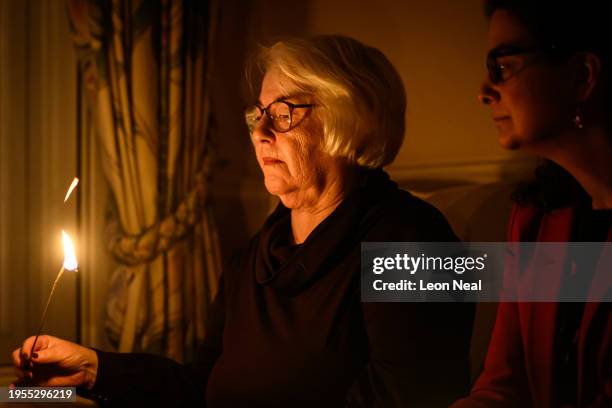 Joan Salter sits with Chief Executive of the Holocaust Memorial Day Trust Olivia Marks-Woldman as she lights a memorial candle at her home in north...