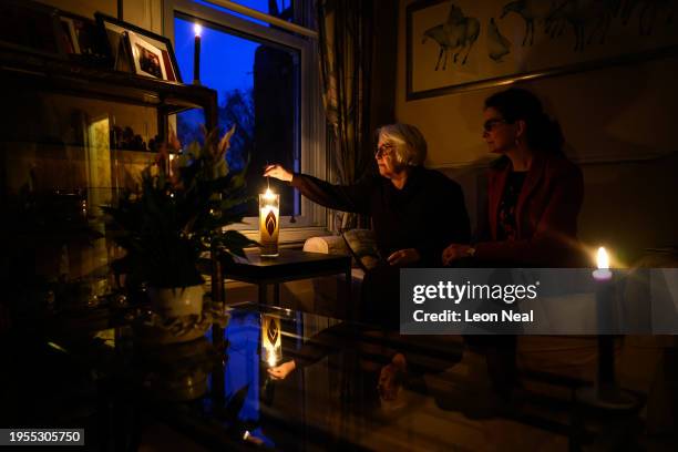 Joan Salter sits with Chief Executive of the Holocaust Memorial Day Trust Olivia Marks-Woldman as she lights a memorial candle at her home in north...