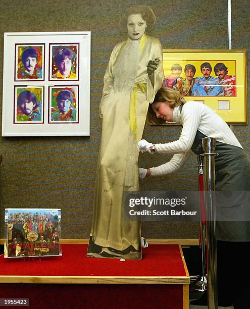 Caitlin Hazel from Christie's puts an autographed life-size standee of Marlene Dietrich, which was used in the famous crowd scene in Peter Blake's...