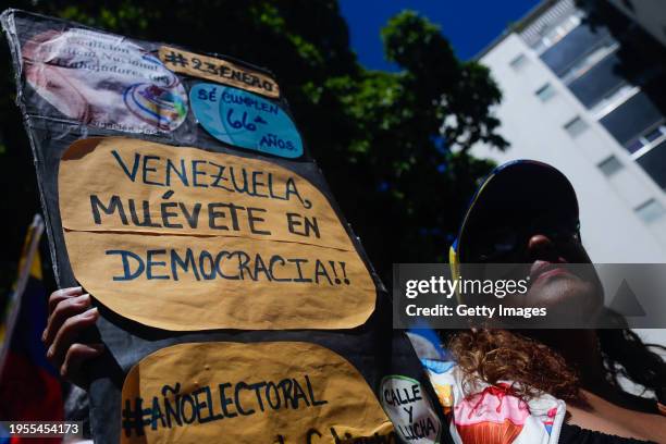 Supporter of presidential Candidate Maria Corina Machado of Vente Venezuela Party holds a banner that reads 'Venezuela move in democracy' during a...