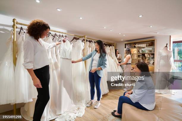 mother and daughter wedding dress shopping - bridesmaid dress photos et images de collection