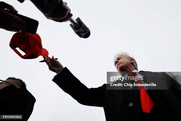 Republican presidential candidate, former U.S. President Donald Trump throws an autographed hat while visiting with supporters outside the polling...