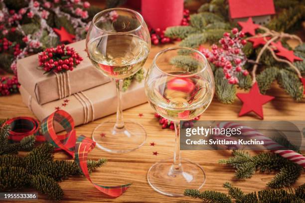 two glasses of white wine with festive christmas decoration - sweet wine stock-fotos und bilder