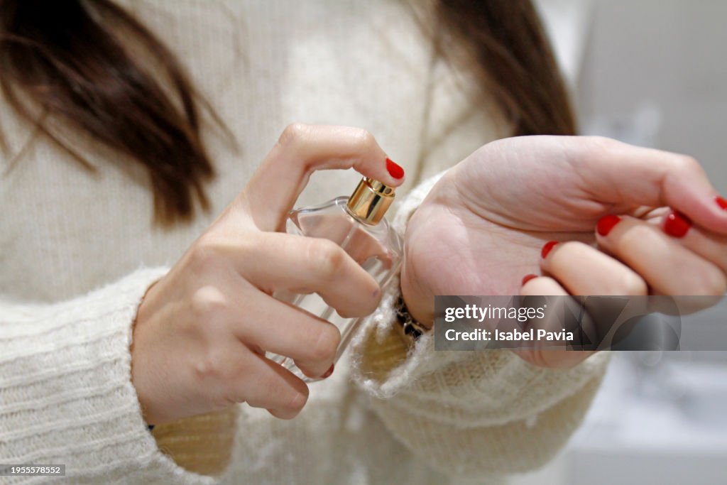 Woman spraying perfume on wrist