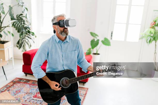 senior man playing the acoustic guitar in virtual reality glasses - gig living room stock pictures, royalty-free photos & images