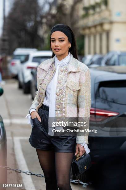 Kelsey Merritt wears hair band, black leather shorts, tights, bag, white blouse, jacket outside Chanel during the Haute Couture Spring/Summer 2024 as...