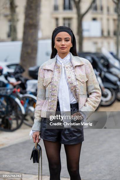 Kelsey Merritt wears hair band, black leather shorts, tights, bag, white blouse, jacket outside Chanel during the Haute Couture Spring/Summer 2024 as...