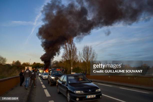 Farmers block the entrance of a Leclerc supermarket in Le Mans, northwestern France, on January 26 as part of a nationwide day of protests called by...