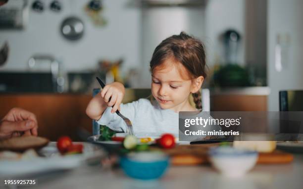 a happy beautiful cute girl having breakfast at home - criança imagens e fotografias de stock