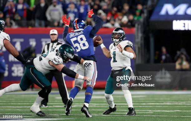 Jalen Hurts of the Philadelphia Eagles in action against Bobby Okereke of the New York Giants at MetLife Stadium on January 07, 2024 in East...