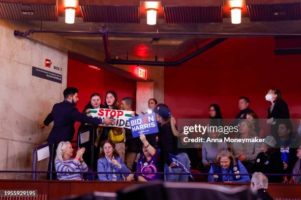 Protester holds a sign reading "Stop Genocide" as they are removed from the crowd while U.S. President Joe Biden speaks at a ”Reproductive Freedom...