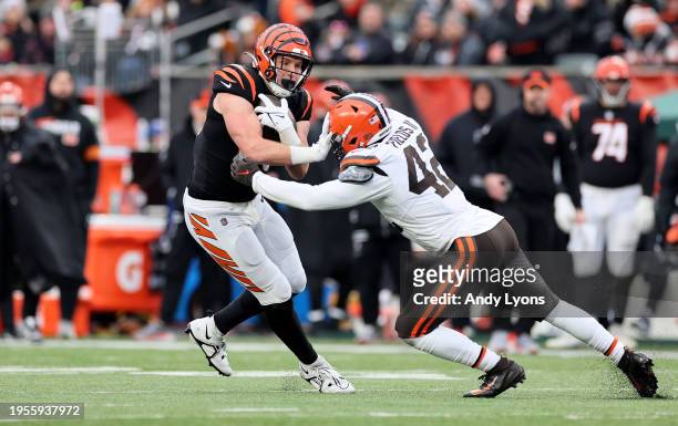 Drew Sample of the Cincinnati Bengals runs with the ball while defended by Tony Fields II of the Cleveland Browns at Paycor Stadium on January 07,...